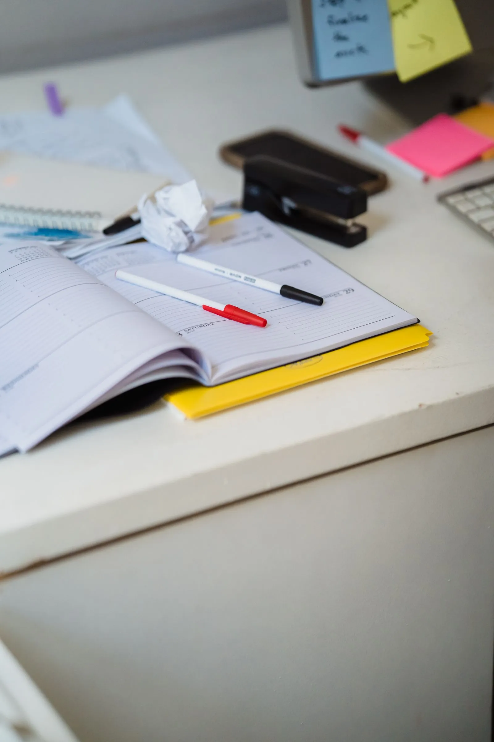 A tidy desk with a water bottle, notebook and resistance band
