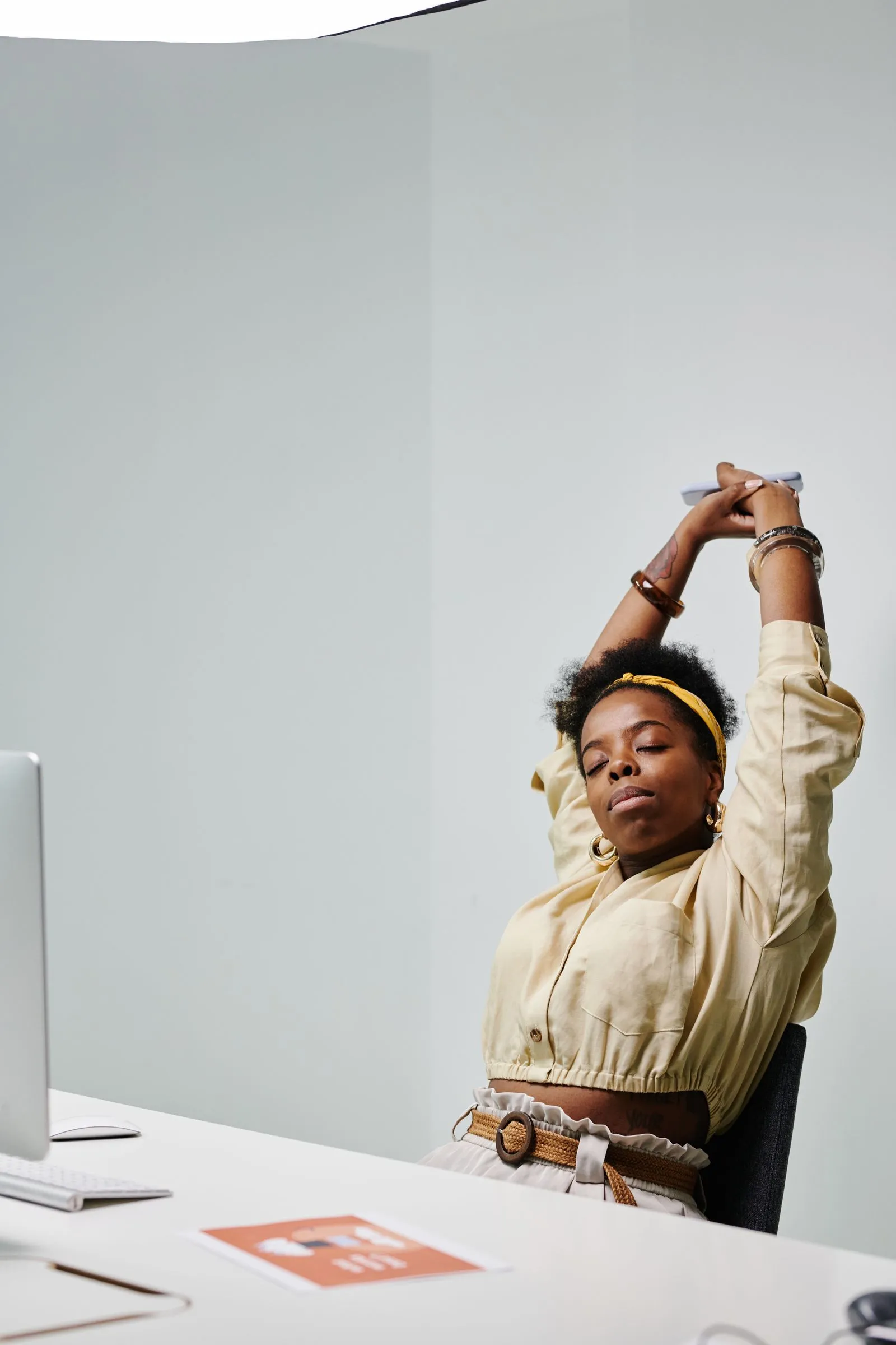 A person standing up from a desk chair to stretch